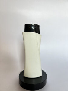 White plastic bottle with black cap for cosmetic packaging, suitable for shampoo, conditioner, or skincare products.