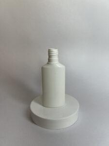 White cosmetic tube bottle without cap on round display stand, ideal for best cosmetic jars and tubes for skincare packaging.