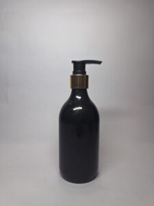 Black pump bottle with gold collar for hair care packaging, suitable for shampoo, conditioner, or hair oil.